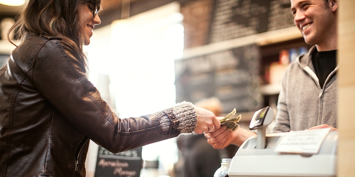 Woman paying with cash in store